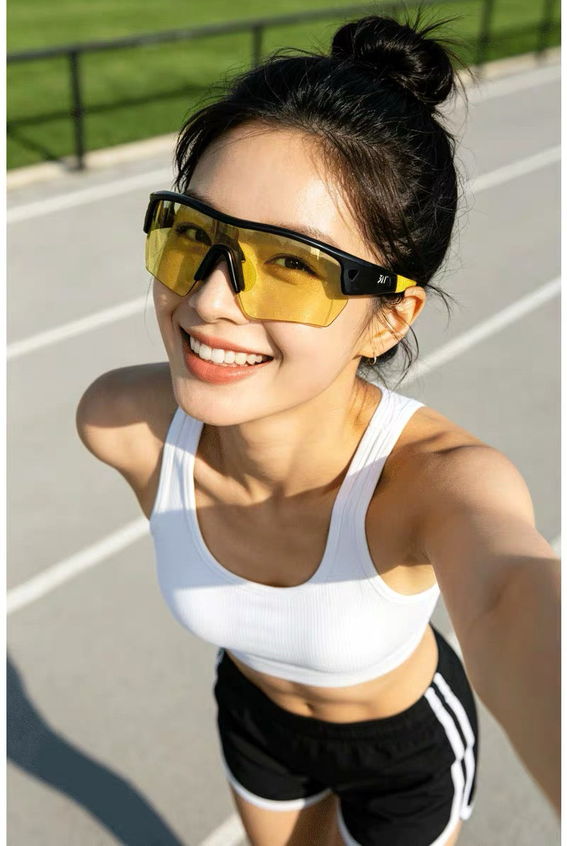 Black and yellow semi-rimless TR shield sports sunglasses worn by an adult woman