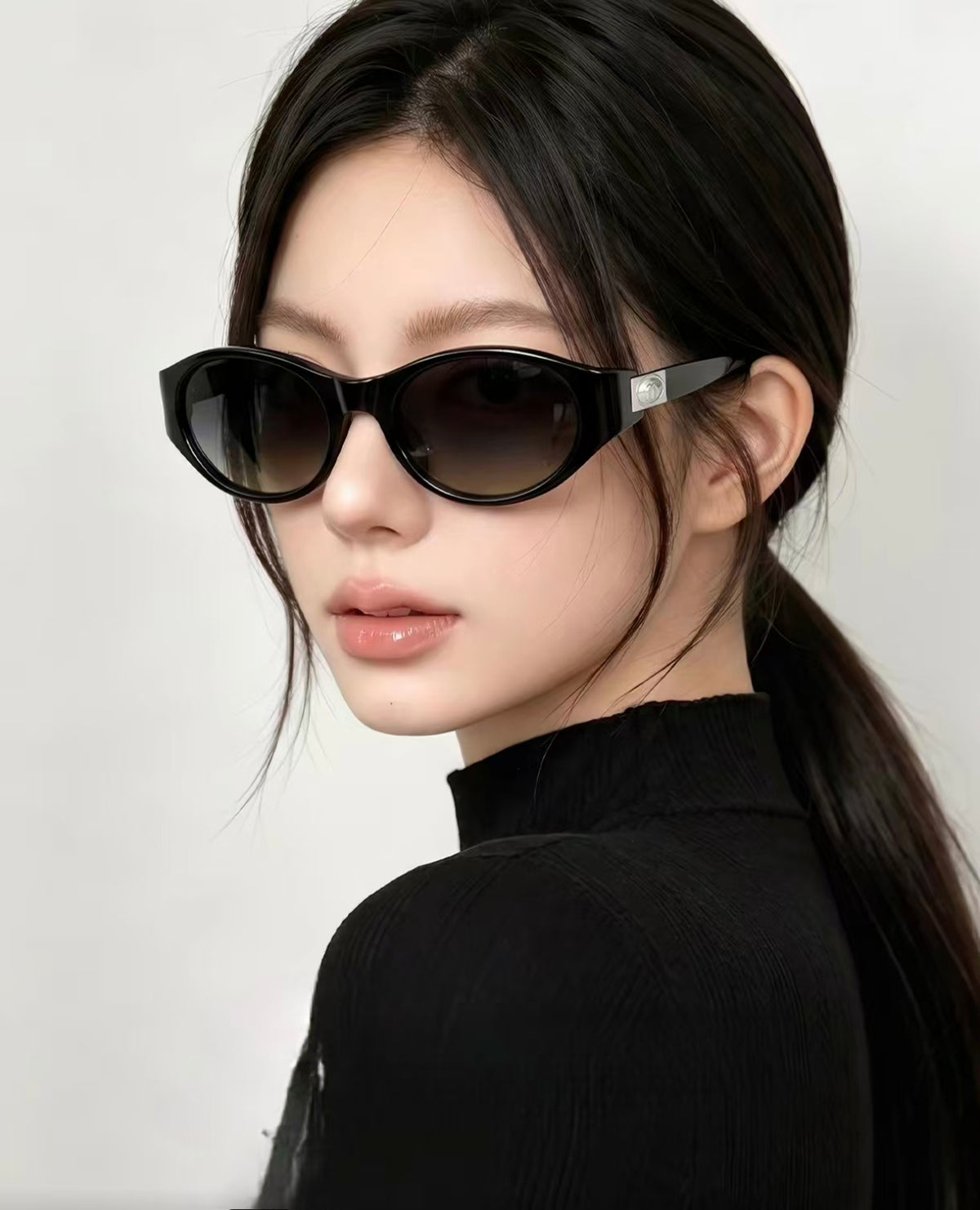Adult woman wearing Glossy Black cat-eye sunglasses, three-quarter portrait