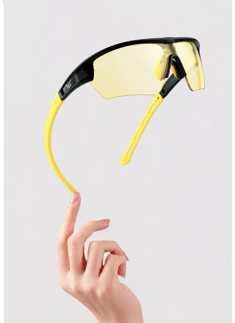 Black and yellow semi-rimless TR shield sports sunglasses, product detail held in hand